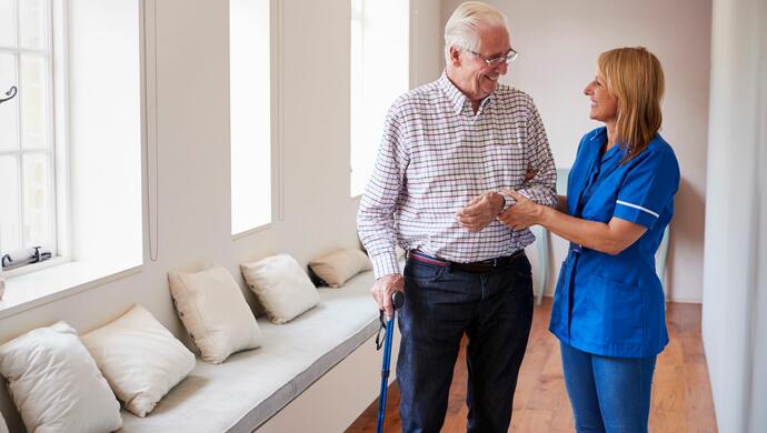 Nurse Helping Senior Man Using Walking Stick