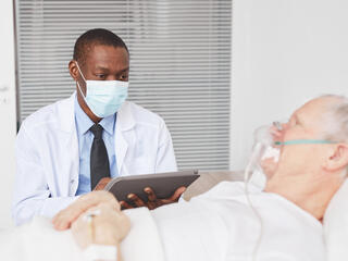 Doctor by senior patient in hospital