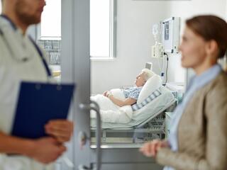 Women talking to Doctor to Visit Grandmother in Hospital